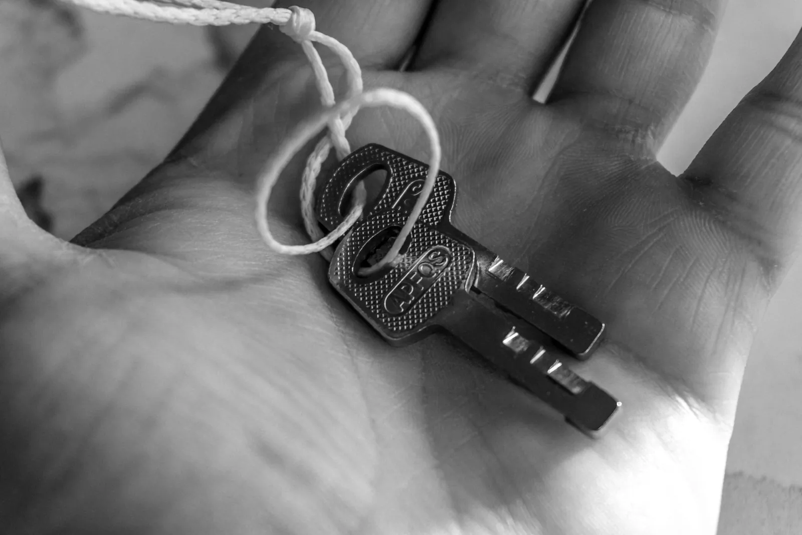 Two keys on a string resting in an open hand