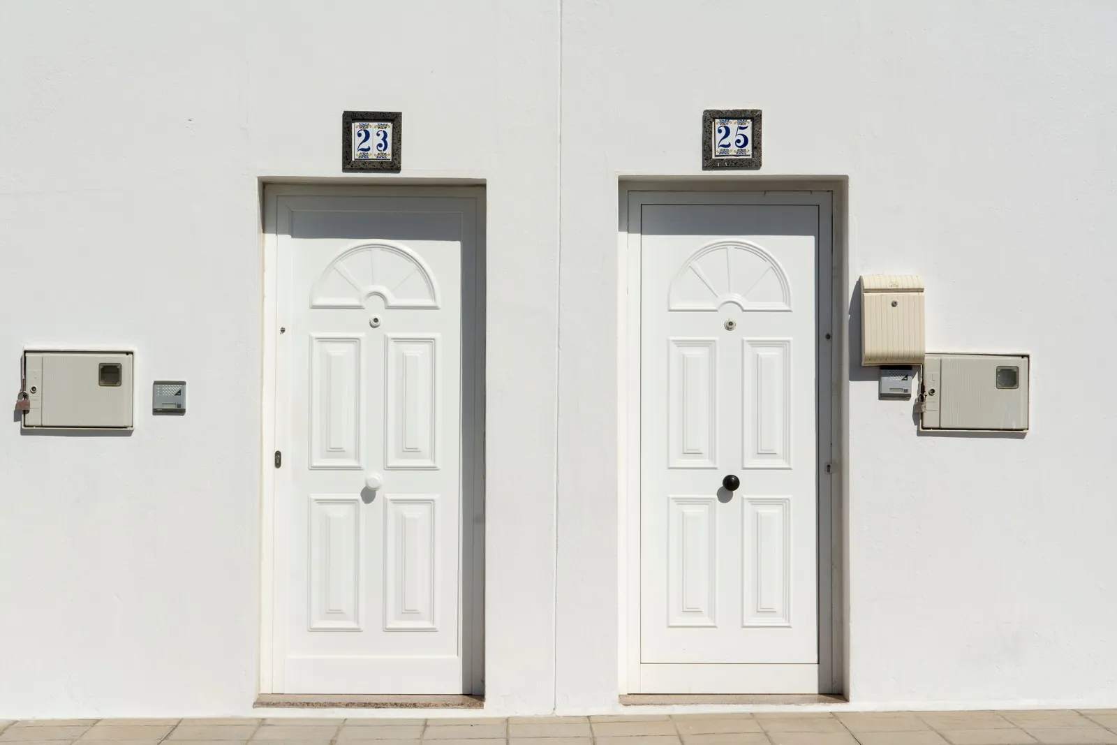 Two white apartment doors with unit numbers above them