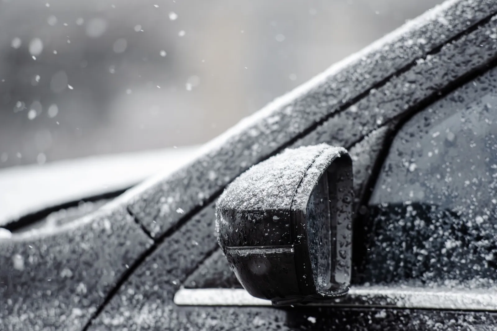 Frost and ice on a car's side mirror and door