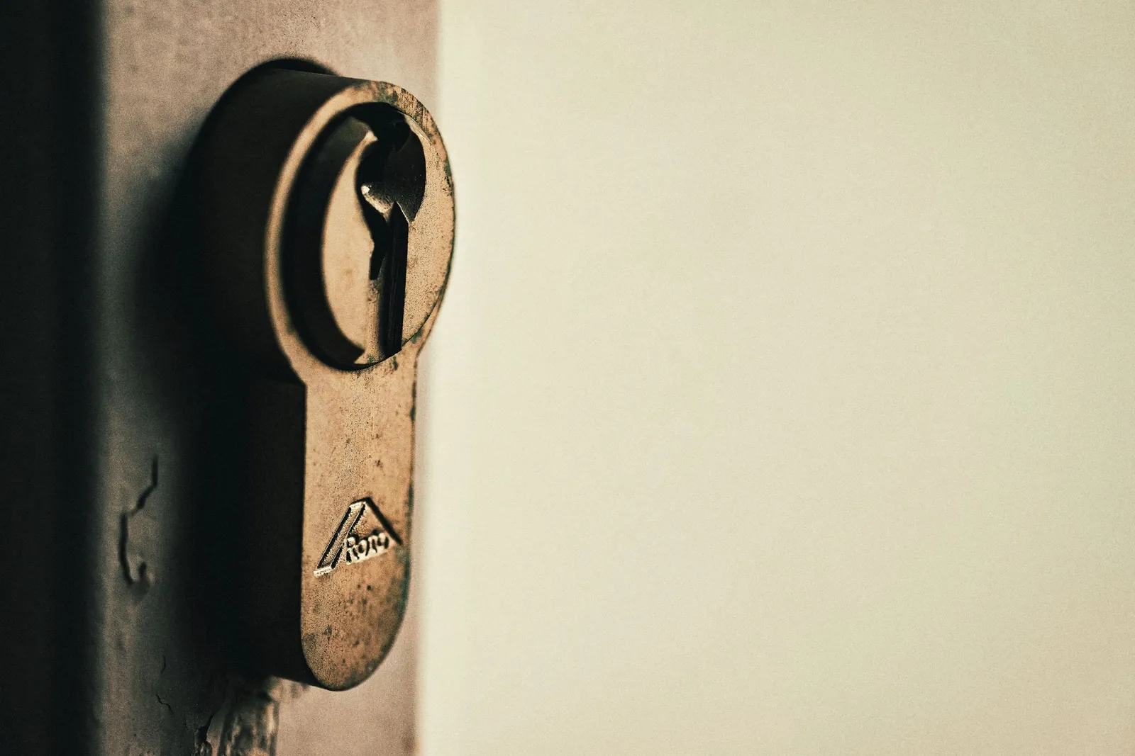 Close-up of a worn brass euro cylinder lock in a door