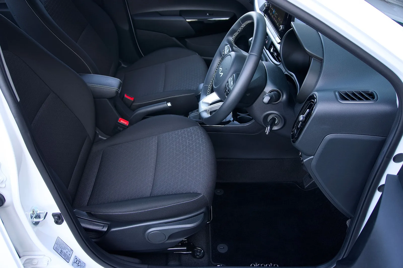 Front seats of a car seen through the open driver's door