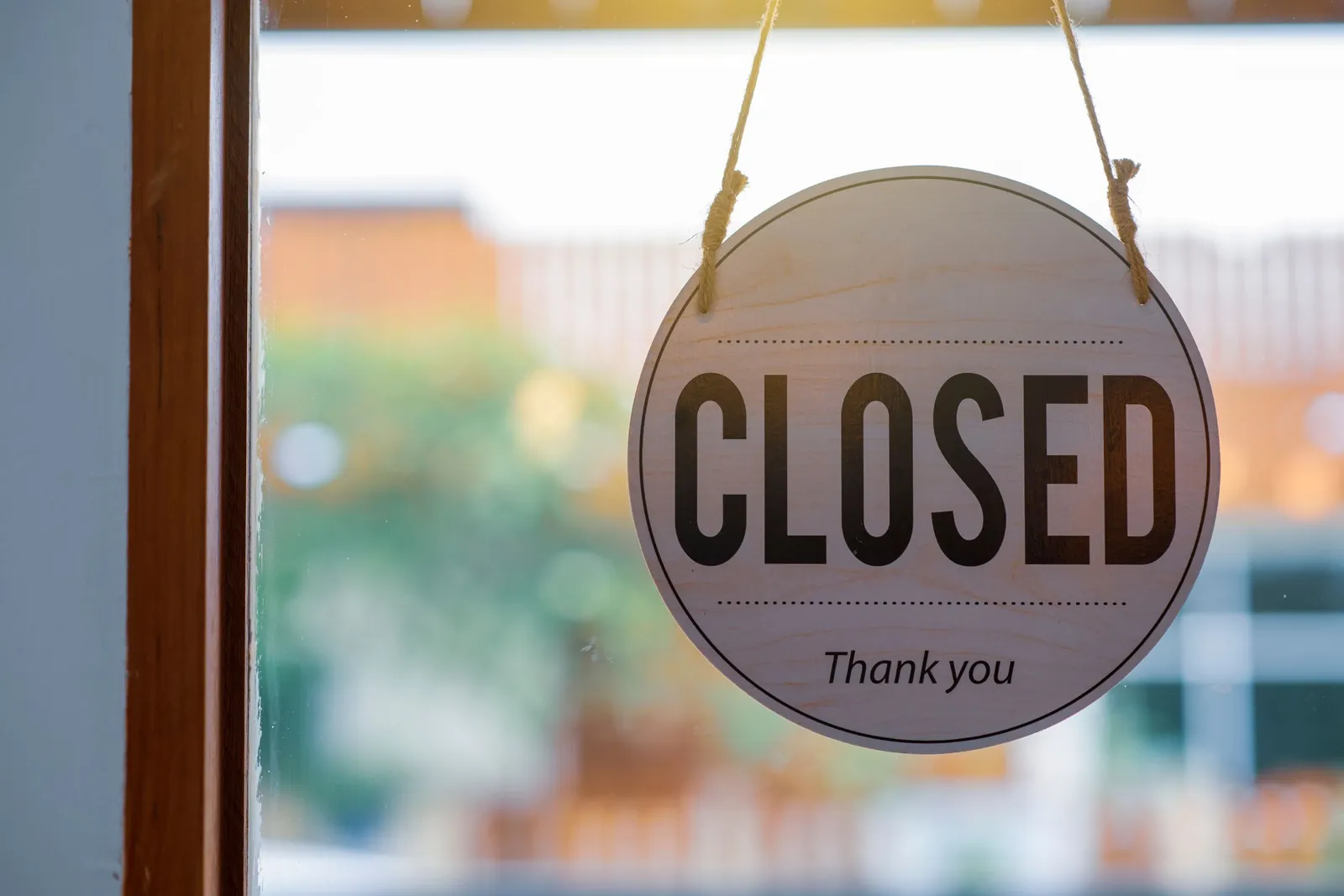 Round closed sign hanging on a shop's glass door