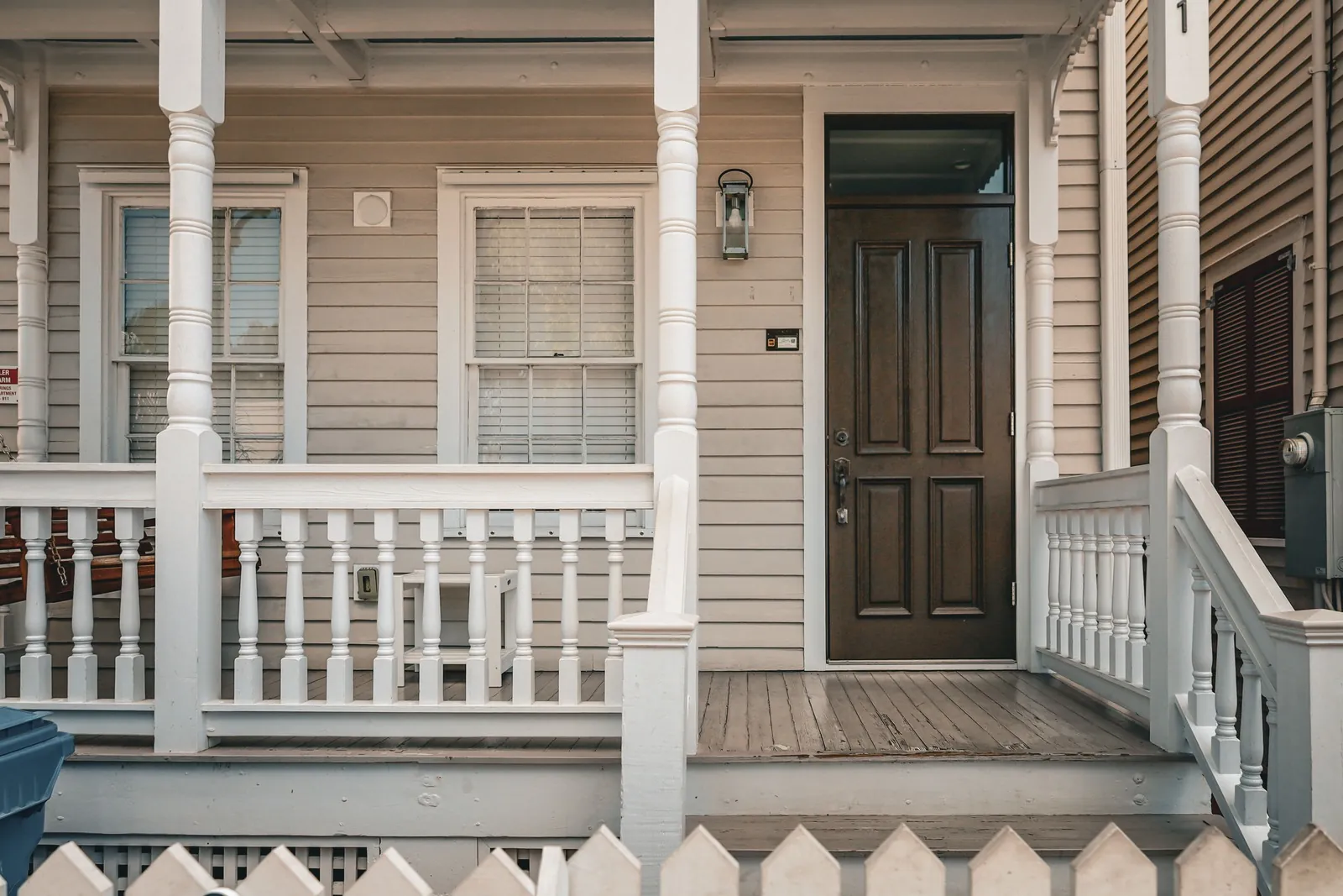 Front door of a white clapboard house with a covered porch