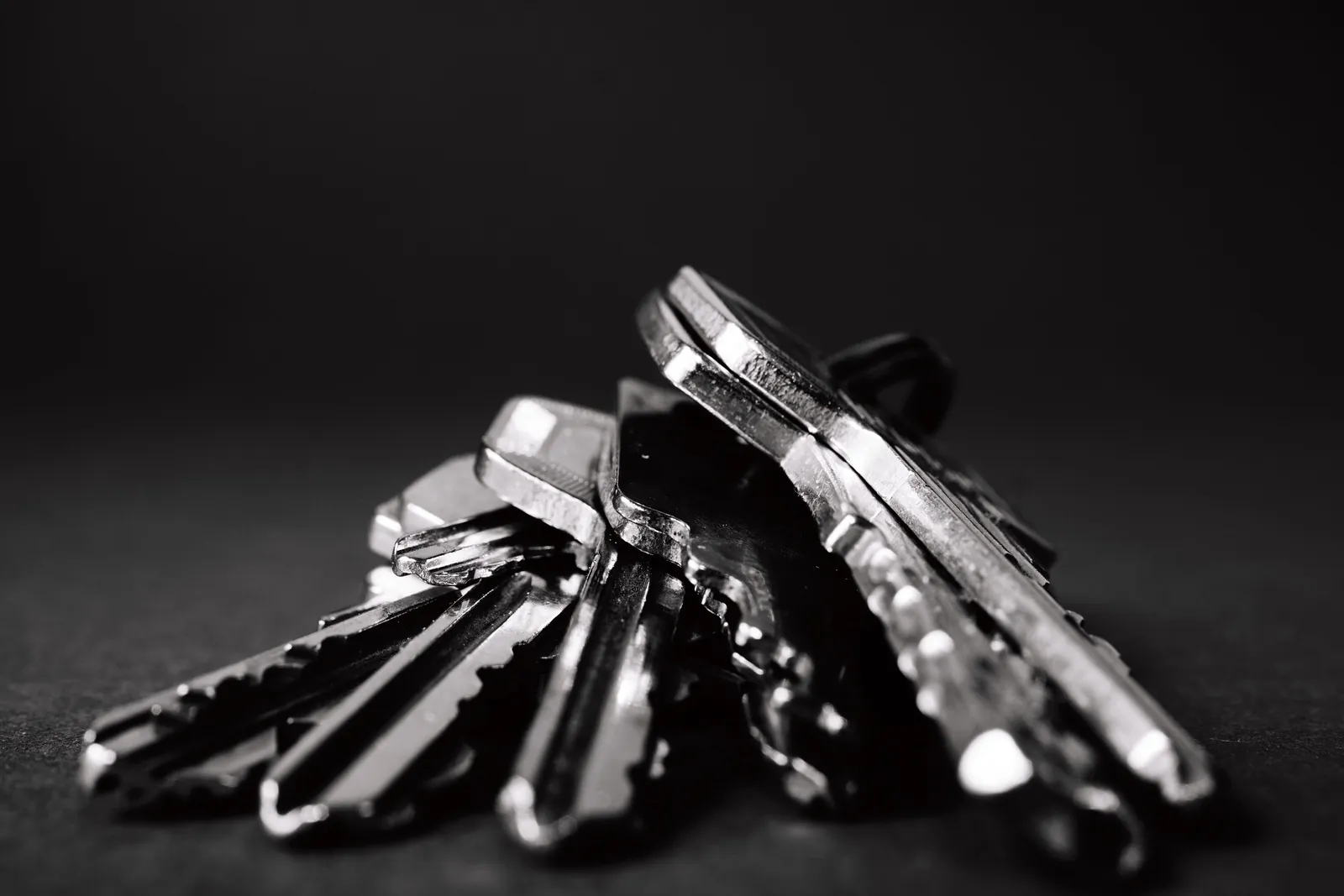 A bunch of door keys on a black background