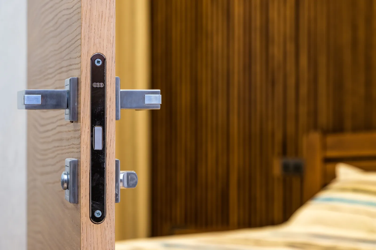 Mortise lock body and lever handles in the edge of an open wooden door