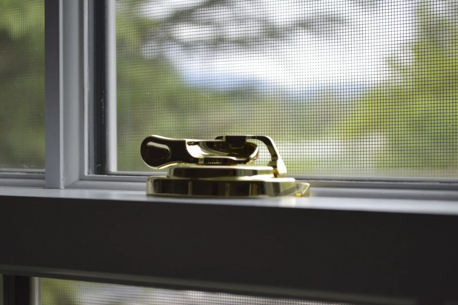 Brass sash lock on a window frame